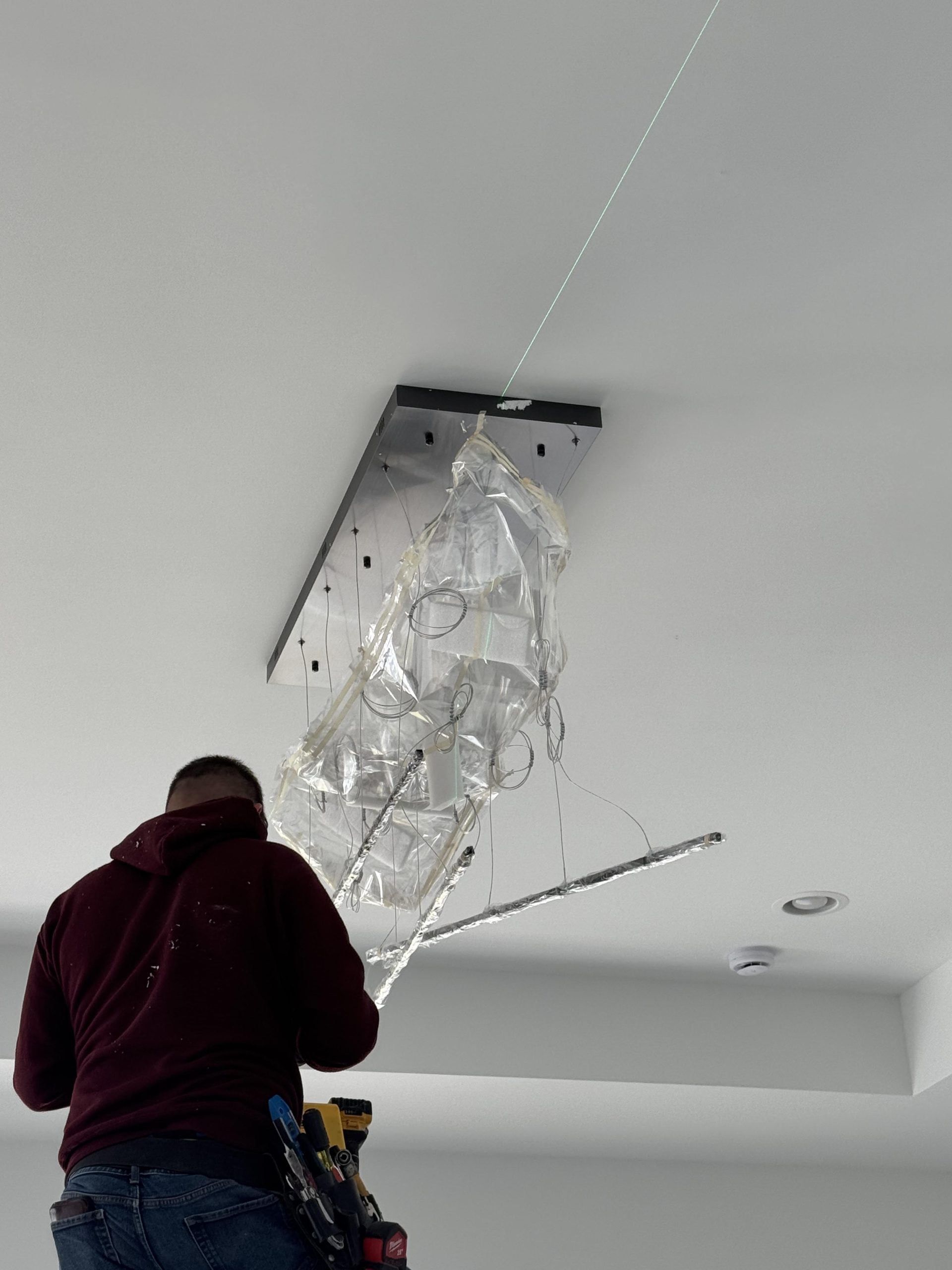 A man attaching lights in the ceiling